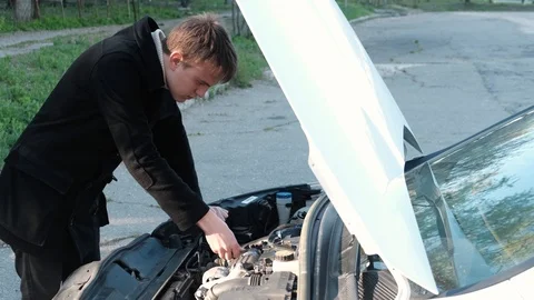 Driver checking engine oil level with dipstick before driving Video stock 106719191