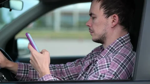 Driver checking notification on his smartphone. Young man uses reads news on the Stock Footage 208872341