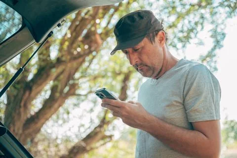 Driver checking online route maps and messages on a smartphone by his vehic.. Stock Photos