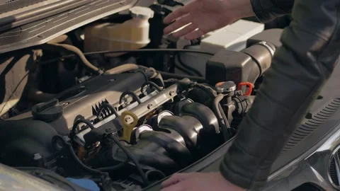 The driver checks the car engine by opening the hood. Close-up of a man's hands. Stock Footage 153923485