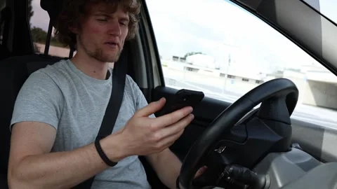 Driver checks phone notifications and ignores the road while driving Stock Footage 343719785