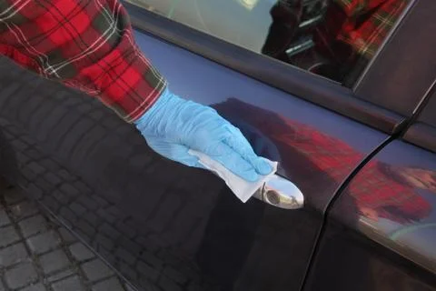 Driver cleaning car handle using antibacterial solution and wet wipes Foto stock