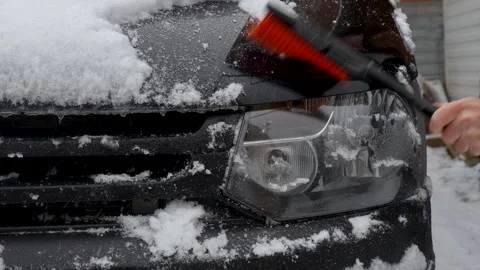 Driver cleaning car headlights from snow, close-up. Stock Footage 255022476