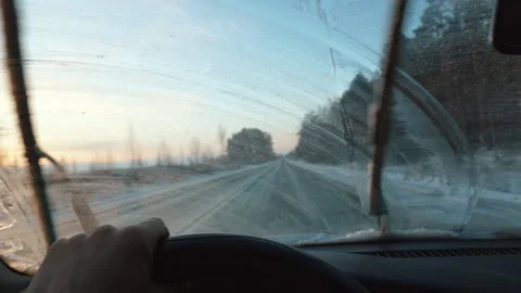 Driver cleaning frozen windshield while driving on winter road 库存影片 302540349