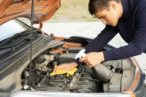 The driver cleans the car engine from dirt Fotos de archivo