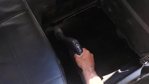 The driver cleans the car interior with a vacuum cleaner Stock Footage 229422532