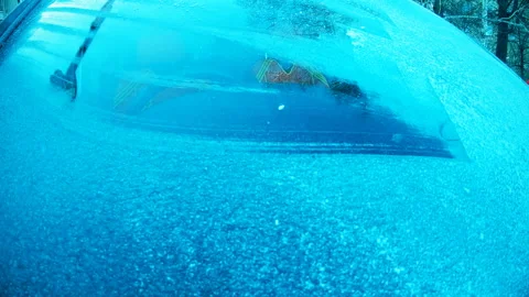 The driver cleans the car windscreen of snow and ice with a scraper,slow motion Stock Footage 120737793