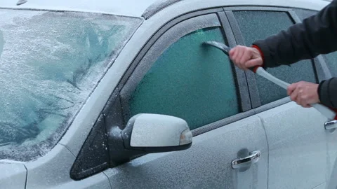 Driver cleans a glass of a car with a scraper Stock Footage 166915615