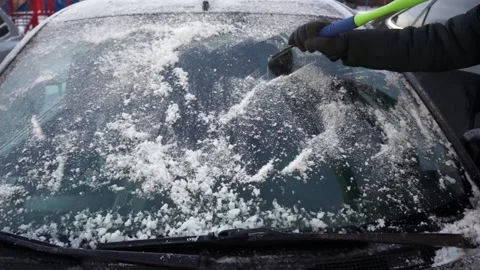 The driver cleans the windshield of the car from ice and snow Stock Footage 146841690