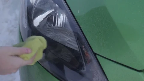 Driver is clearing headlamp with cleanser outdoor Stock Footage 73756344