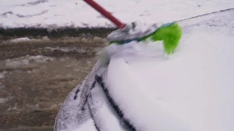 The driver clears the car from the snow Stock Footage 104064321