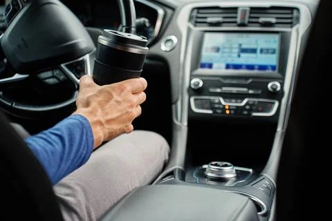 Driver with coffee cup inside car Stock Photos
