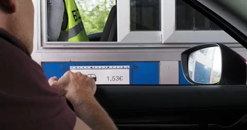 Driver completing a contactless payment at a highway toll booth through an open Stock-Footage 300617609