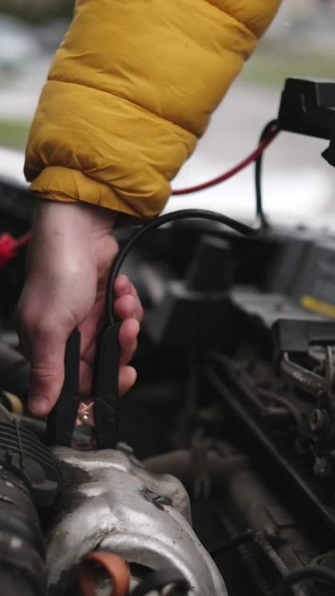 Driver Connecting A Jump Starter Battery To Car Engine Video stock 329133875