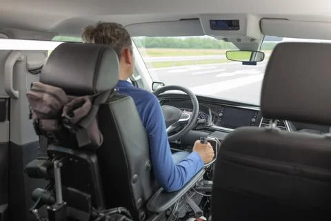 Driver with disability using adapted car on the road Stock Photos
