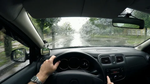 Driver drives a car in the rain on a wet street. Raindrops on the windshield Stock Footage 99403152