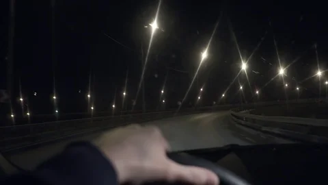 The driver drives a car through the night city, the beautiful streets 库存影片 81185139