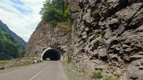 Driver driving forward view along a mountain highway through a rocky gorge Stock Footage 343776019