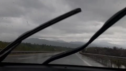 Driver driving in rain storm on highway with windshield wipers in cloudy weather Stock Footage 154417410