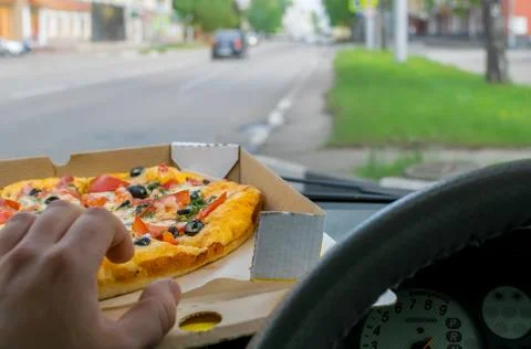 Driver eats pizza in the car Foto stock