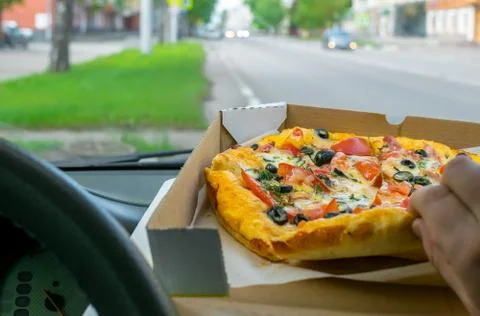 Driver eats pizza in the car Stock Photos