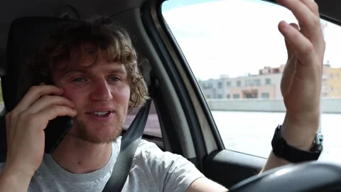 Driver enjoys a phone conversation while driving and loses focus on traffic Stock Footage 343720404
