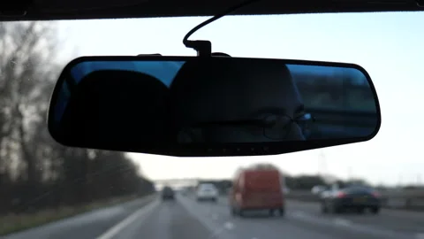 Driver face in the mirror and blurred motorway Vídeos de archivo 169411749
