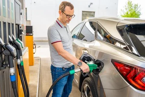 The driver fills up expensive gasoline in self-service filling station in Europe Stock Photos