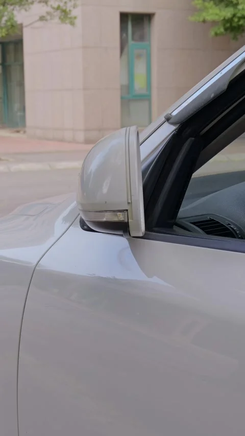 The driver folds in the left side mirror by hand. Stock Footage 329397822