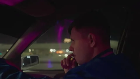 Driver gazes while vaping at night, Night vehicle operator using phone and Stock Footage 324956589
