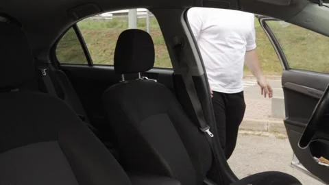 The driver gets into the car and fastens his seat belt, the man prepares to.. Stock Footage 252020238