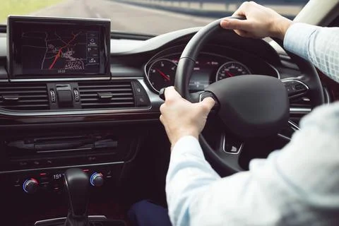 Driver is gripping steering wheel while checking GPS screen inside flat design Stock Photos