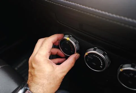The driver hand adjusts the temperature of the car air conditioner Foto stock