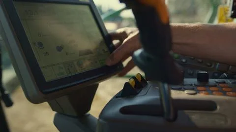 Driver hand control combine automatic system screen at countryside closeup. Stock Photos