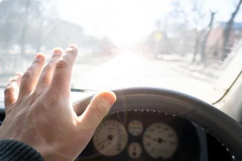The driver hand covers the glare of the sun Stock Photos