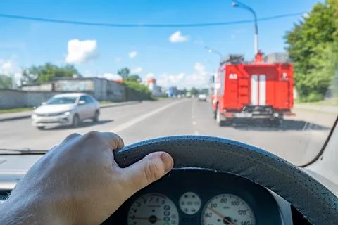Driver hand is inside on the steering wheel of a car Stock Photos