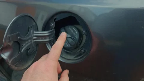 Driver hand opening car fuel cap then gesturing no refusal due to expensive Stock Footage 333246957