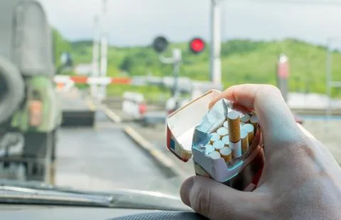 Driver hand with a pack of cigarettes Stock Photos