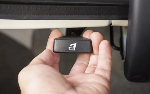 The driver hand is pulling on the car second seat folding button Stock Photos