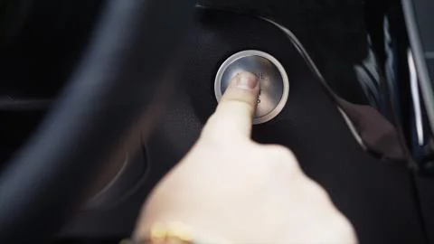 Driver hand pushes engine start stop button. Stock. Modern luxury crossover car Stock Photos