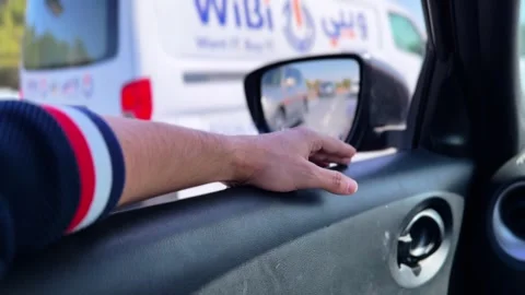 Driver Hand Resting on Car Door Near Side Mirror in Daylight Traffic 動画素材 331670540