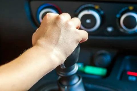 Driver hand shifting gear shift knob manually, selective focus Stock Photos