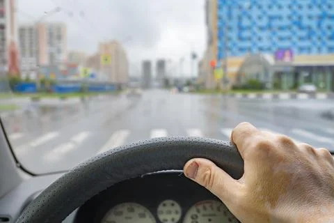 Driver hand on the steering wheel inside the car Stock Photos