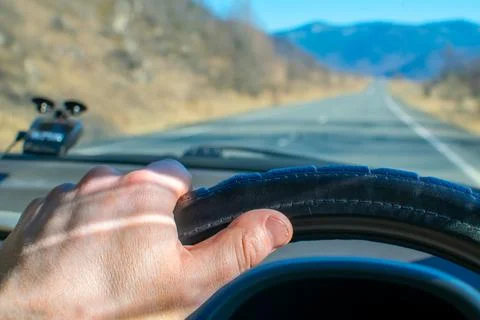 Driver hand on the steering wheel inside the car Stock Photos