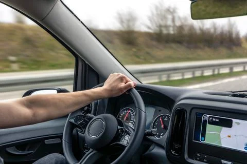 Driver Hand On Steering Wheel With Navigation Screen Fotos de archivo