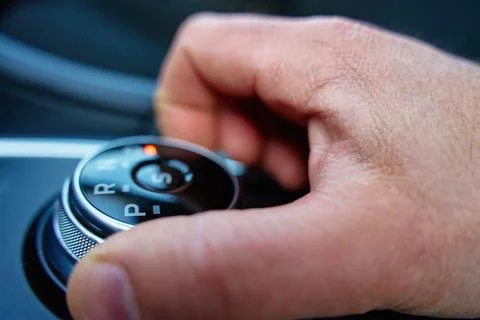 Driver hand turning automatic gear selector in car Stock Photos