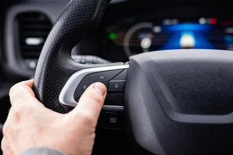 Driver hand using steering wheel controls in modern vehicle Stock Photos