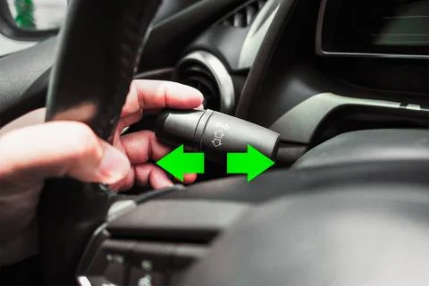 Driver hand using turn signal in a car Stock Photos