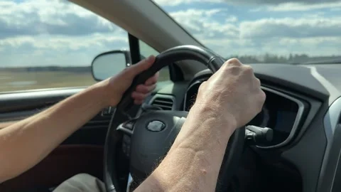 Driver hands grip a steering wheel inside a moving car. Close view of the v.. Stock Footage 333196943