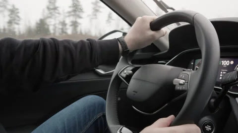 Driver hands on steering wheel during countryside road trip in rainy weather Stock Footage 325113861